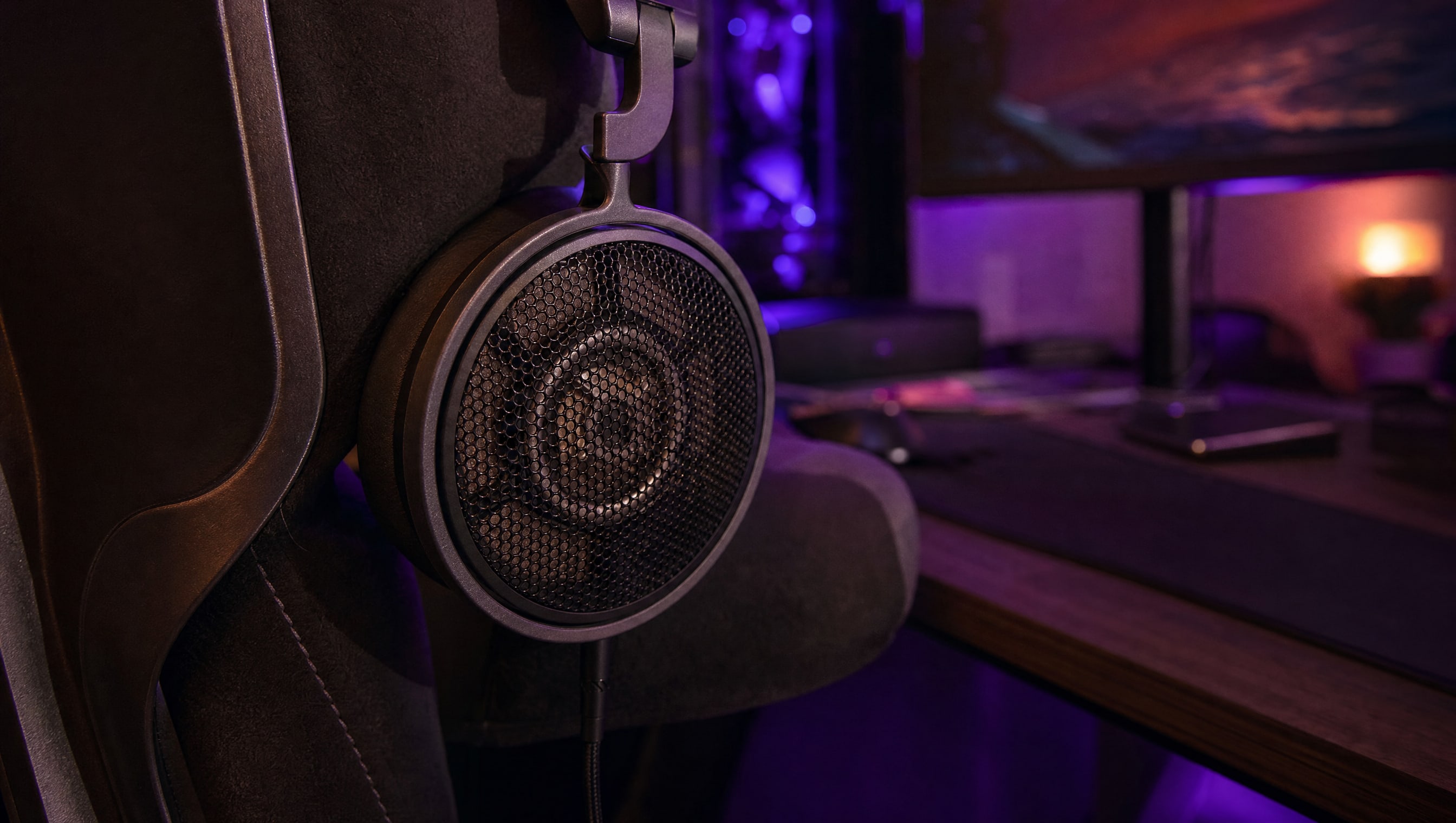 An open-back headphone earcup seen from behind, the grille showing the driver through it.
