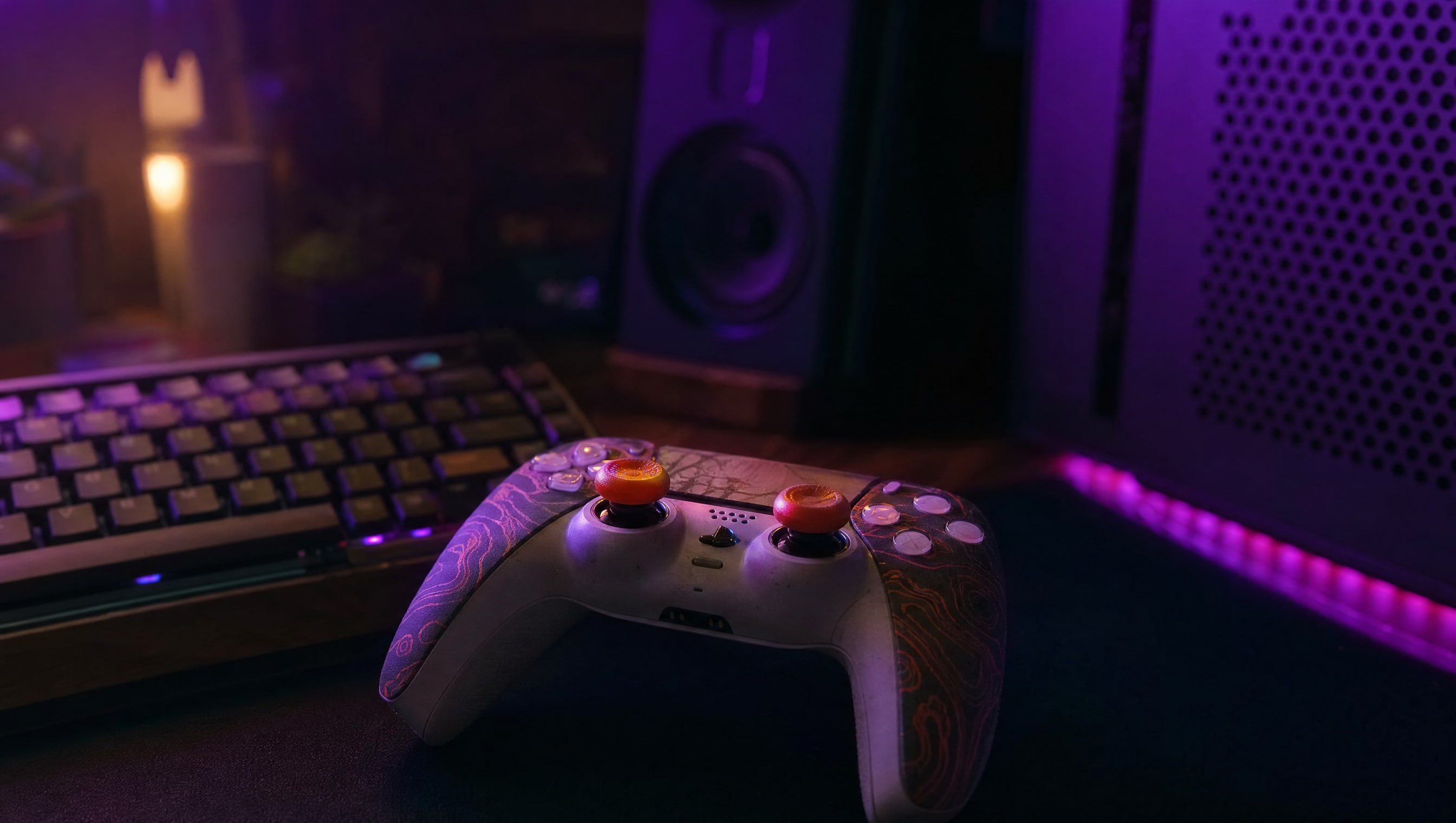 A controller wearing an aftermarket faceplate and tall coloured thumbstick caps.