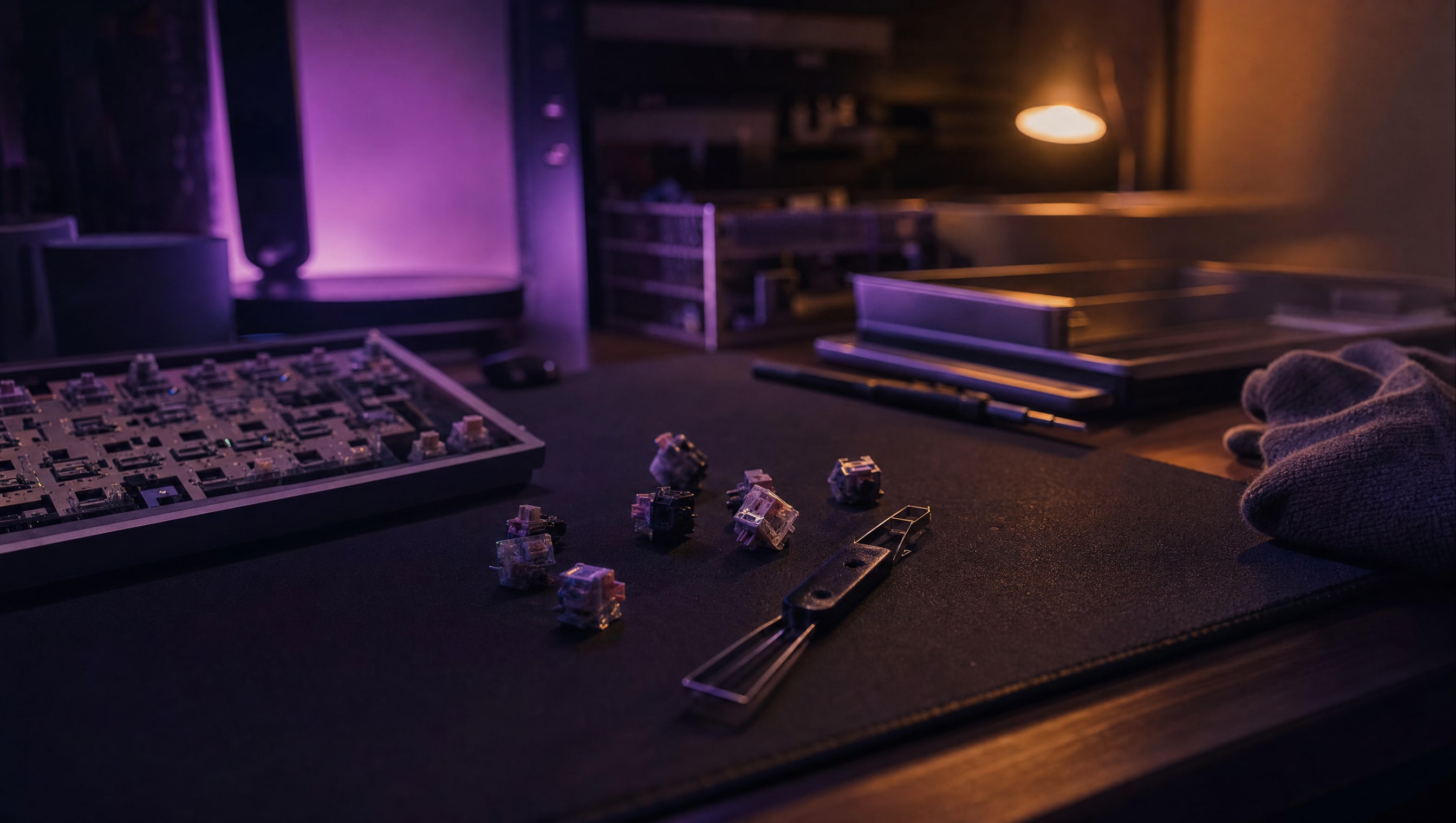 A dozen loose switches scattered on a dark mat, housings catching violet light.
