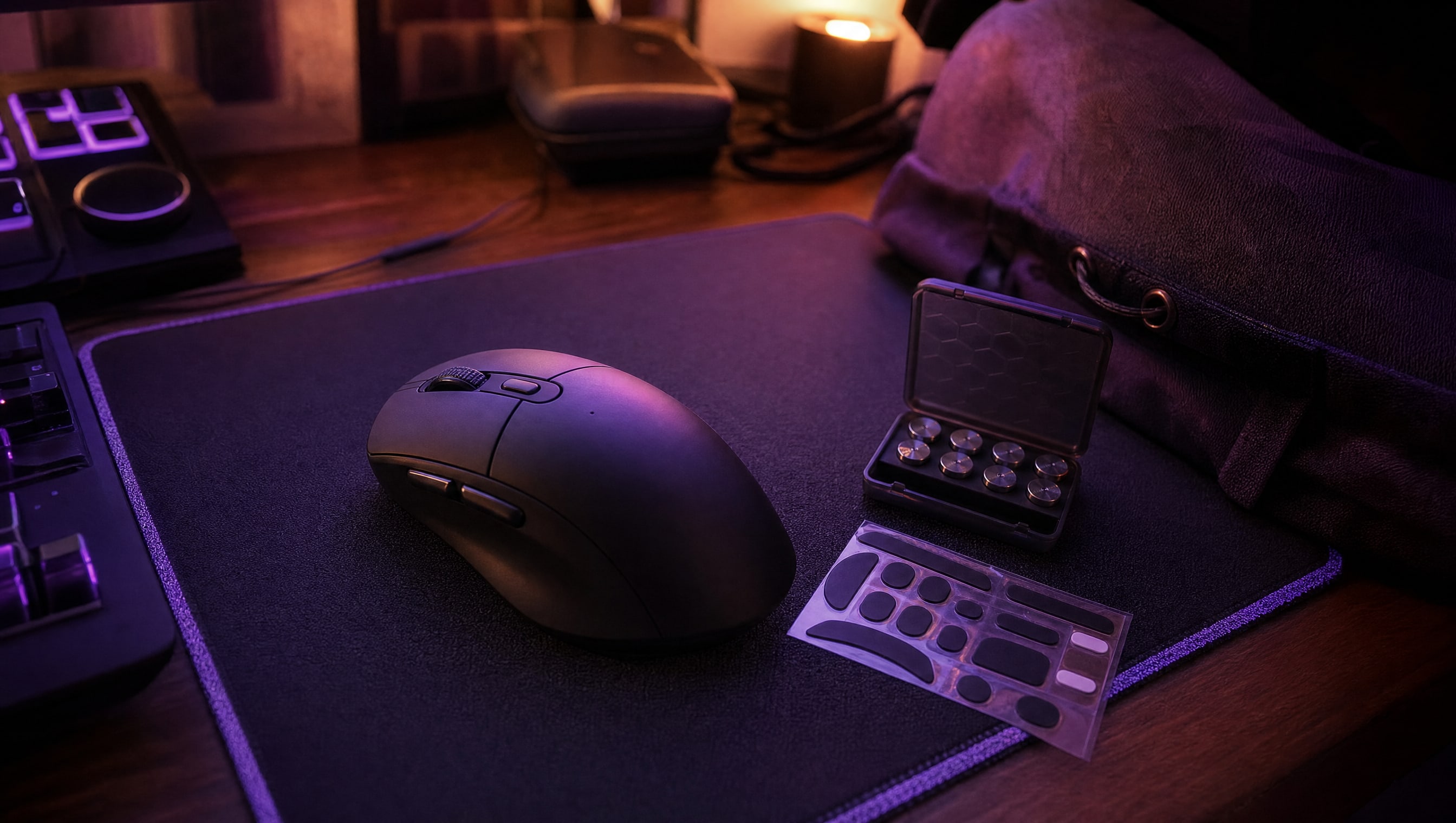 A desk at night: a mouse, a pad, spare skates and a small weight set.