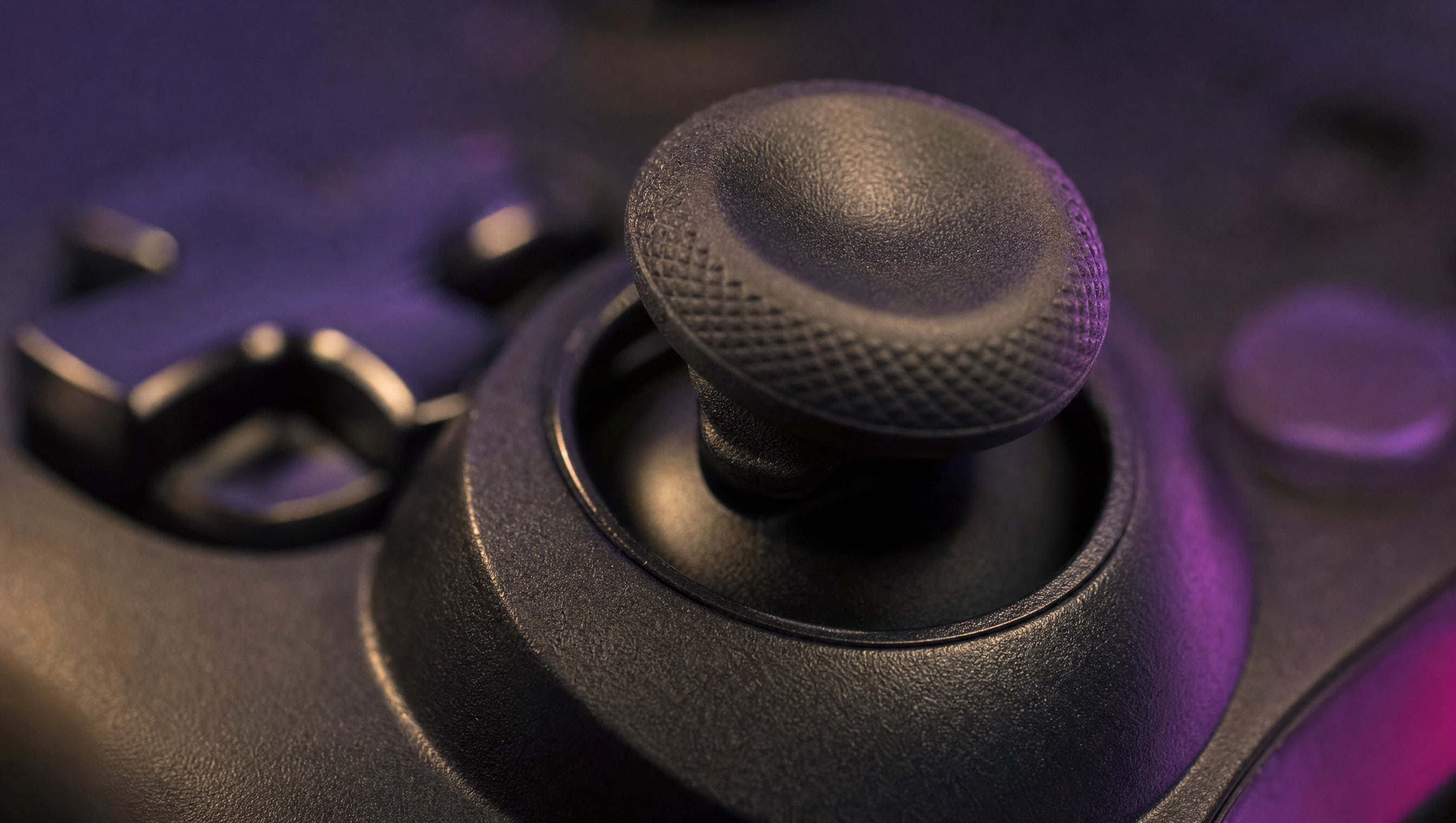 Five controllers of different shapes lined up in a row under warm light.
