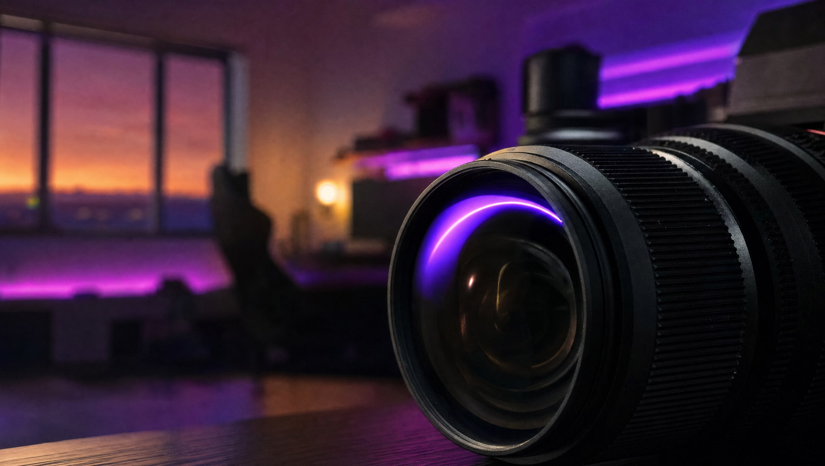 Macro on a camera lens barrel, the focus ring knurling sharp, a violet highlight across the element.