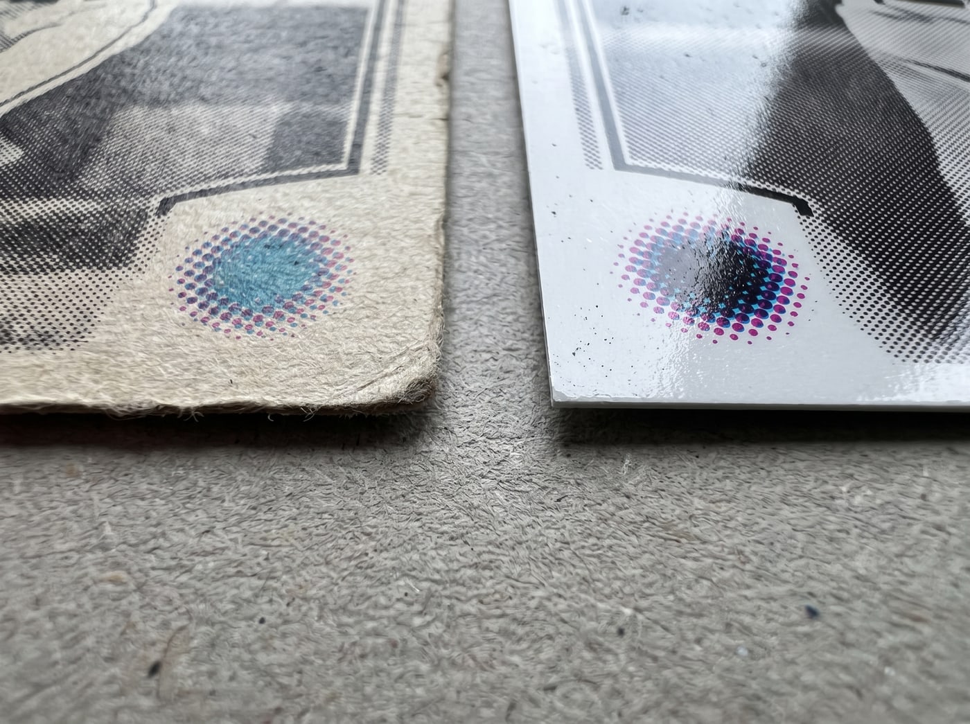 Two trading cards laid side by side on grey blotting board, the left one old with a soft frayed edge, the right one modern with a hard glossy cut edge.