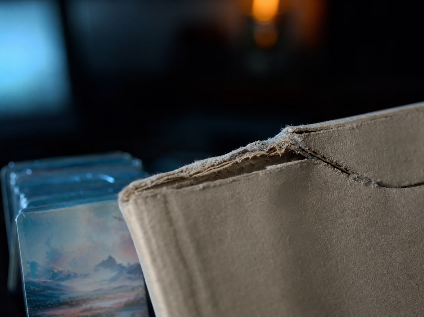 Macro on the sealed edge of a rigid cardboard mailer, the fibres torn where the tab has been pressed.